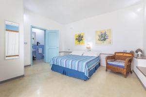 une chambre avec un lit et une chaise dans l'établissement I Mirti - Home Holiday, à Marina di Mancaversa 83 autres photos