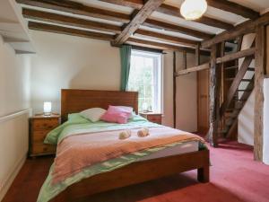 a bedroom with a bed in a room with wooden ceilings at Chilton Manor House in Murston
