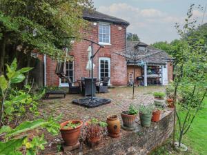 a garden with potted plants in front of a house at Chilton Manor House in Murston