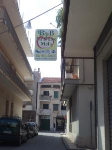 an alley with parked cars and a sign on a building at B&B Affittacamere La Dolce Mela in Francavilla di Sicilia