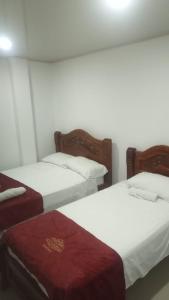 two beds sitting next to each other in a room at Hotel Santa Bárbara Mompox in Mompos