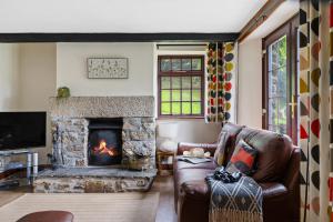 a living room with a couch and a fireplace at Myrtle Grove in Saint Endellion +27 photos