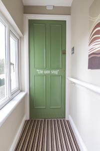 a green door in a room with a window at The Wee Snug Portrush in Portrush
