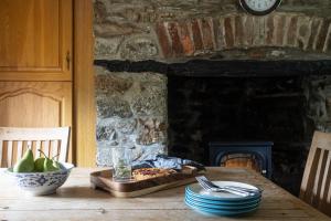 a wooden table with a pizza and a fireplace at Myrtle Grove in Saint Endellion