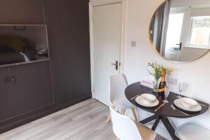 a dining room with a table and chairs and a mirror at The Wee Snug Portrush in Portrush +9 photos