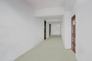 SPOT ON Anmay في Phāphāmau: ممر فارغ بجدران بيضاء وباب مفتوح