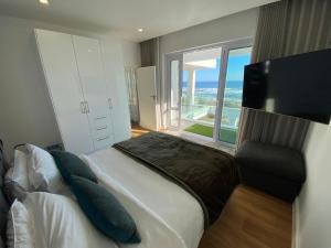 een slaapkamer met een bed en een groot raam bij Ocean Dream Beach Villa in Yzerfontein +60 foto's