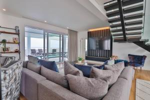 een woonkamer met een grote bank en een televisie bij Ocean Dream Beach Villa in Yzerfontein