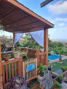 a wooden deck with a pergola and some plants at Bangaló Buzio Relax in Portal