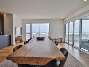 een grote houten tafel in een kamer met stoelen bij Ocean Dream Beach Villa in Yzerfontein