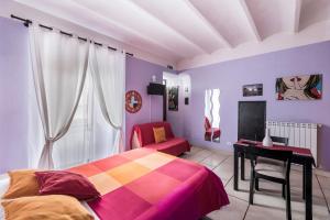 a bedroom with purple walls and a bed and a desk at Appartamento Tivoli Train Station in Tivoli