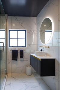 a bathroom with a sink and a mirror at The Kings Domain, DUCHESS - Luxurious townhouse in the CBD! in Blenheim