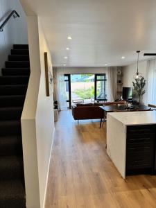 an open living room with a staircase and a desk at The Kings Domain, DUCHESS - Luxurious townhouse in the CBD! in Blenheim