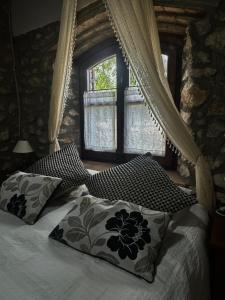 a bedroom with a bed with pillows and a window at Mas del Drac in Castellví de la Marca