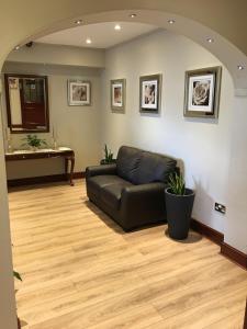 a living room with a black couch and a table at Balkan Lodge Oxford in Oxford