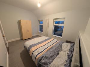 a bedroom with a bed and two windows at Quiet Private Room in Prime Location in Derry Londonderry