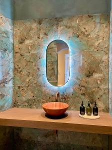 a bathroom with a bowl sink and a mirror at La Ruche Oostende in Mellet