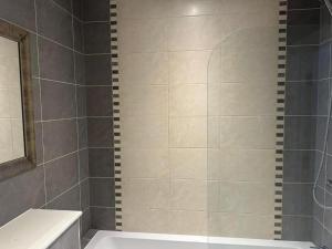 a bathroom with a shower with a tub and a sink at The Cassius Apartment Huntingdon in Huntingdon