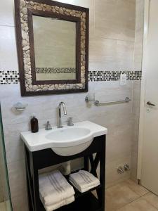 a bathroom with a sink and a mirror at DEPARTAMENTO MIRAMAR in Miramar