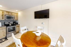 une cuisine avec une table en bois et des chaises blanches dans l'établissement The View IV at Sheepscot River, à Edgecomb