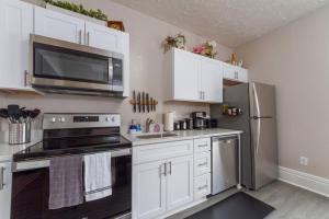 スポケーンにあるHistoric 3 Bed 1 bath Near Downtown Spokaneの白いキャビネットとステンレス製の冷蔵庫を備えたキッチン +32枚の写真