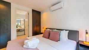 a bedroom with a large white bed with red pillows at Casa di Chibi Chibi - Brand new apartment with pool close to the beach in Jan Thiel