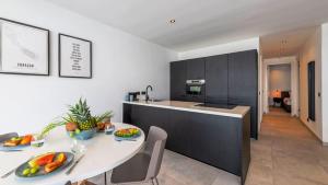 a kitchen and dining room with a white table and chairs at Casa di Chibi Chibi - Brand new apartment with pool close to the beach in Jan Thiel