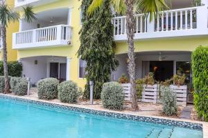 a hotel with a swimming pool in front of a building at Azure Haven in Willemstad