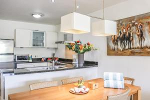 a kitchen with a wooden table and a kitchen with white cabinets at Azure Haven in Willemstad +26 photos