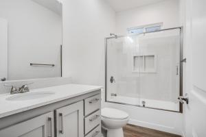 a white bathroom with a toilet and a shower at Privately Secluded Guesthouse in Fremont +4 photos