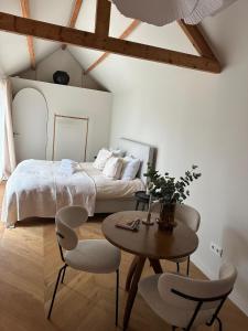 Un dormitorio con una cama y una mesa y sillas. en Studio Cabana Oegstgeest, en Oegstgeest