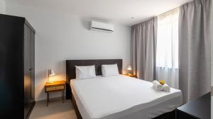 a bedroom with a large white bed and a window at Dushi Breeze in Blue Bay
