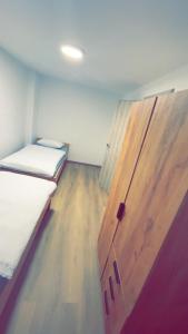 Zimmer mit 2 Betten und einer Holztür in der Unterkunft Apartma Center Ljutomer in Ljutomer