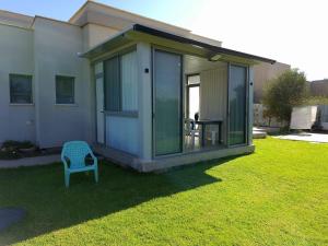 une petite maison avec une chaise bleue dans une cour dans l'établissement צימר חספין, à Haspin