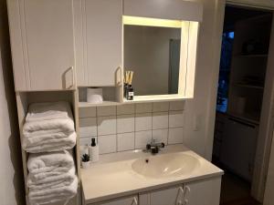 a bathroom with a sink and a mirror and towels at Bright and spacious 3 bedroom with balcony close to the city in Aabenraa +5 photos