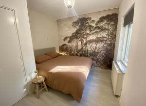 Un dormitorio con una cama con un cuadro en la pared. en Cozy forest house ideal for relaxing, en Wateren