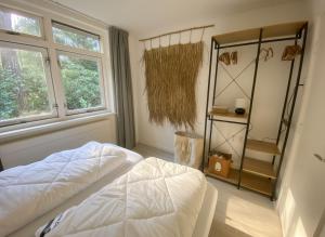 Un dormitorio con una cama blanca y una ventana. en Cozy forest house ideal for relaxing, en Wateren