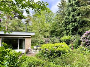 una casa con un jardín con flores y árboles en Cozy forest house ideal for relaxing, en Wateren