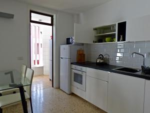 a kitchen with white cabinets and a sink and a table at Apartment Edificio Altemar in Playa de las Americas