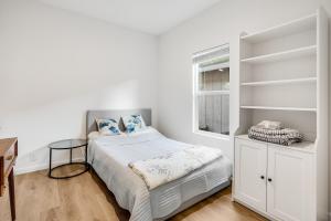 a white bedroom with a bed and a desk at Privately Secluded Guesthouse in Fremont