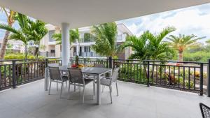 a balcony with a table and chairs and palm trees at Luxe Breeze in Blue Bay