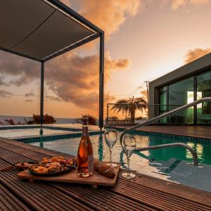 a table with food and wine glasses next to a swimming pool at Villa Sea View Luxury in Willemstad