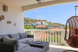 Una sala de estar con un sofá y un balcón. en Little Dreams, en Dorp Sint Michiel