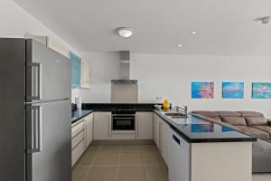 una cocina con refrigerador y estufa horno superior en Little Dreams, en Dorp Sint Michiel