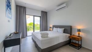 a bedroom with a large white bed and a window at The Breeze 50 in Willemstad