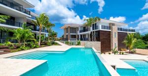 a villa with a swimming pool in front of a house at The Breeze 50 in Willemstad