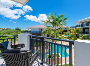 a balcony with chairs and a swimming pool at The Breeze 50 in Willemstad
