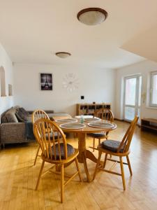 a living room with a wooden table and chairs at Srdce Mesta V Podkroví - slnečný apartmán s balkónom in Stará Turá