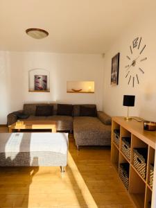 a living room with a couch and a clock on the wall at Srdce Mesta V Podkroví - slnečný apartmán s balkónom in Stará Turá