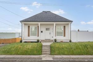 a small white house with a white door and grass at Updated Family Friendly Hillyard Gem NEW HOT TUB! in Spokane